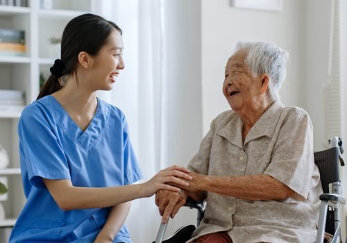 Young Asian woman, nurse, caregiver, carer of nursing home talking with senior Asian woman feeling happy at home